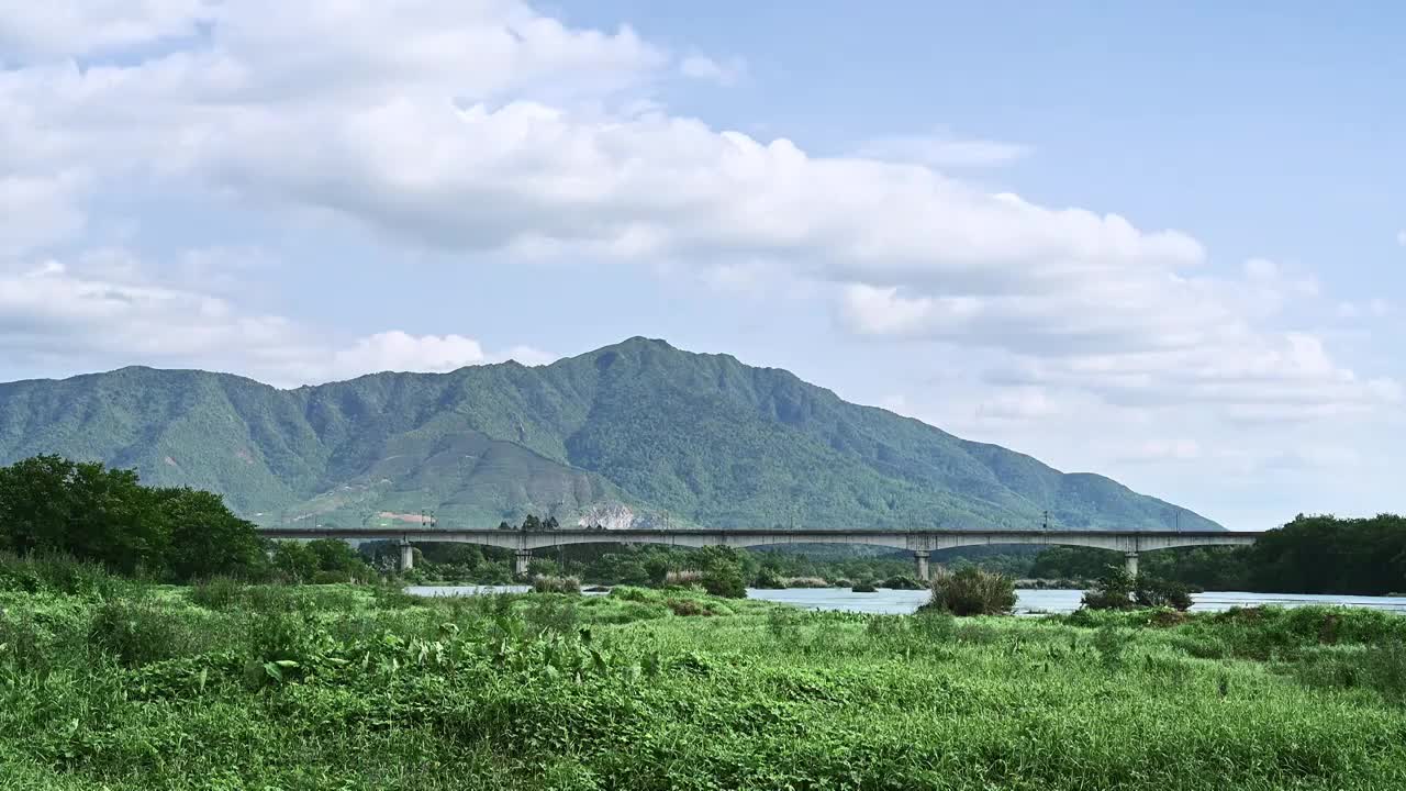 桂林漓江边的草地和远山下横跨漓江的铁路桥视频素材