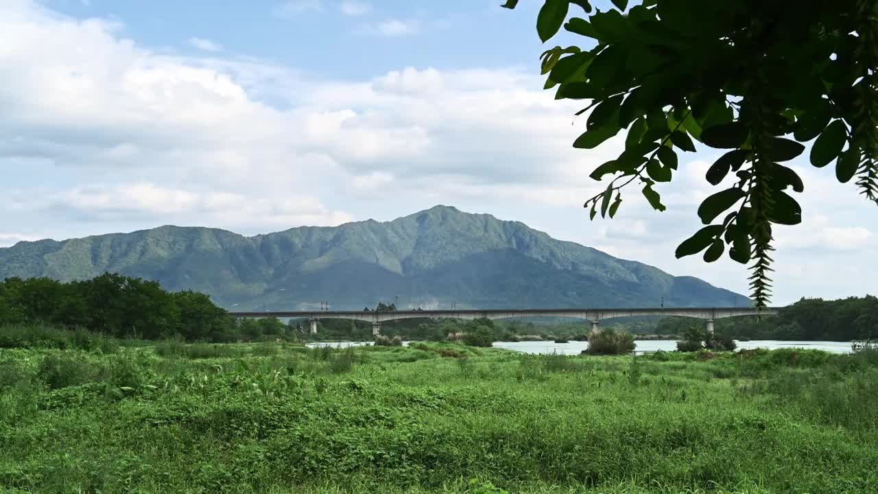 桂林漓江边的草地和远山下横跨漓江的铁路桥视频素材