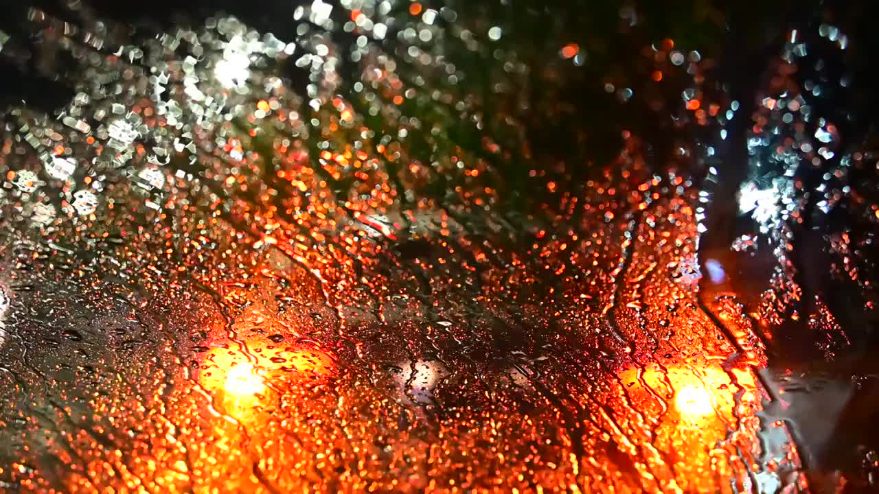 暴雨中的车窗玻璃与城市夜景光斑视频素材