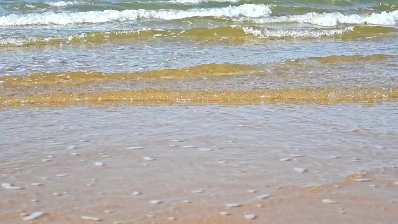 夏天的海边海滩上波浪泛起朵朵浪花视频素材