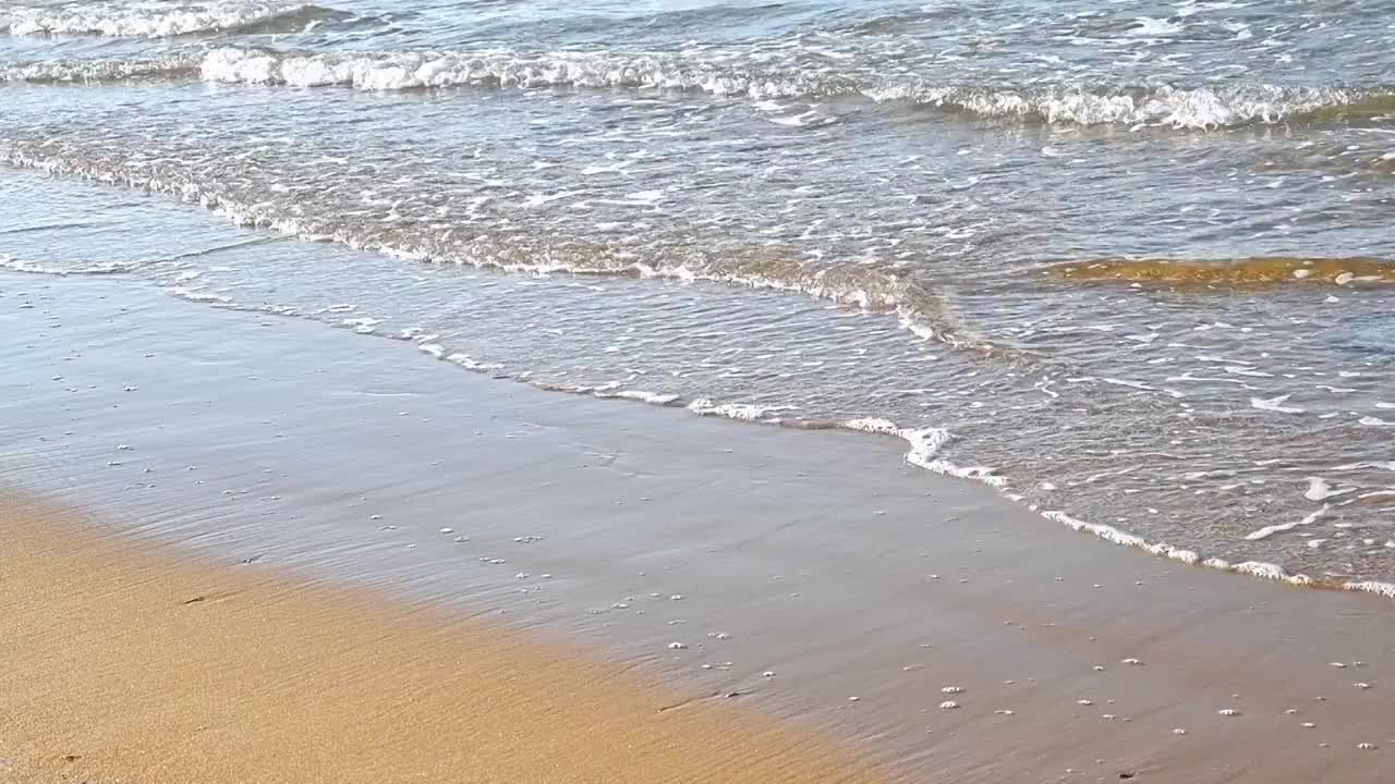 夏天的海边海滩上波浪泛起朵朵浪花视频素材