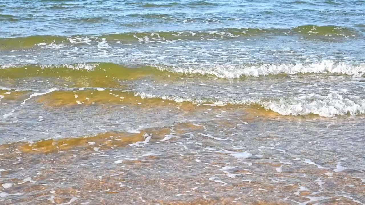 夏天的海边海滩上波浪泛起朵朵浪花视频素材