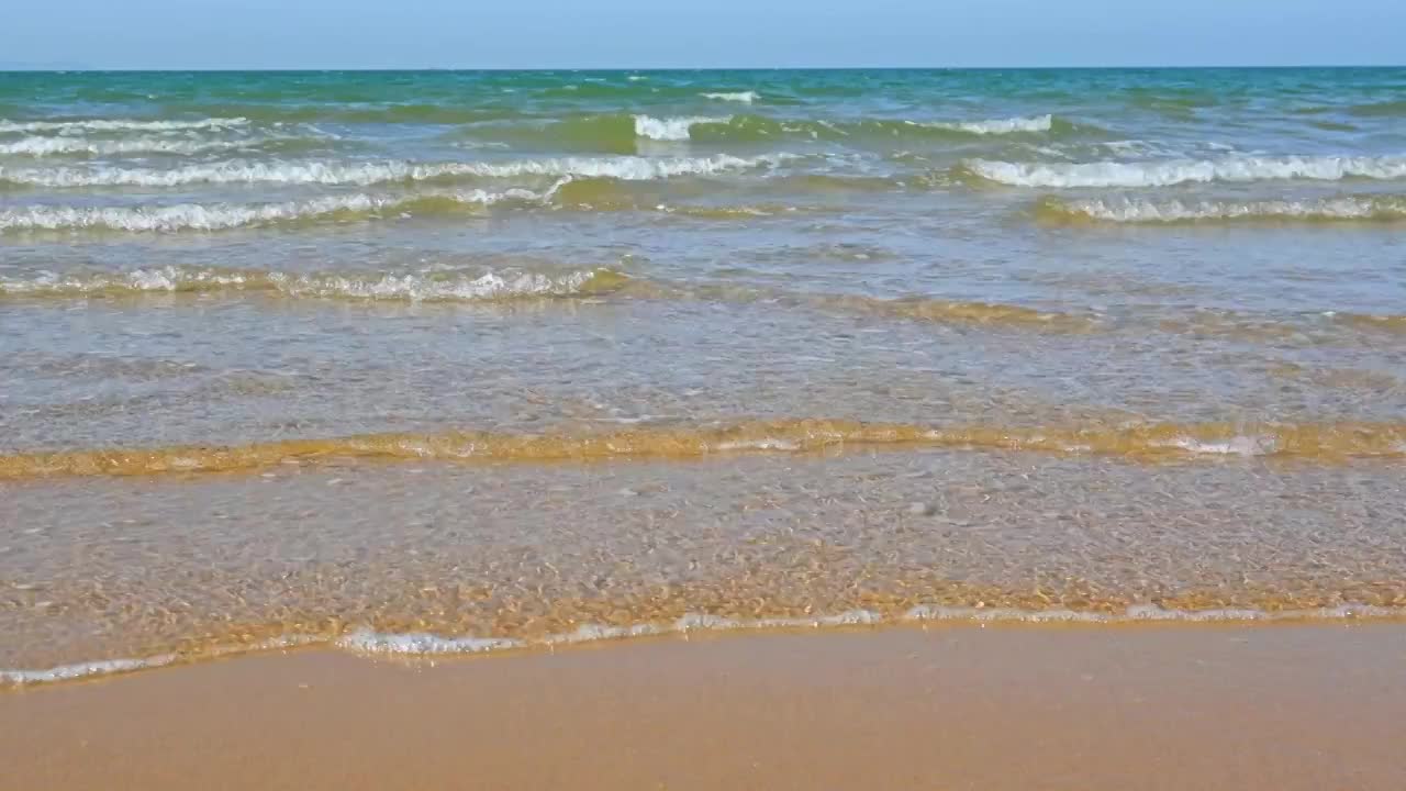 夏天的海边海滩上波浪泛起朵朵浪花视频素材