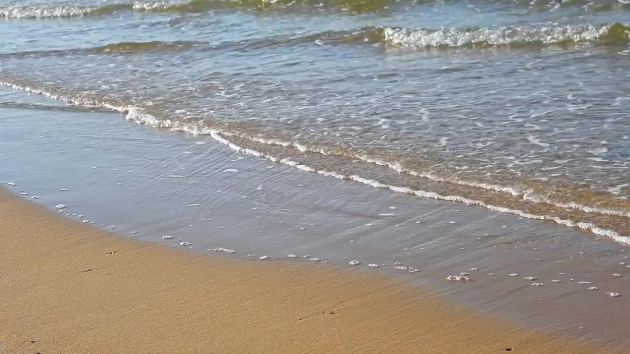 夏天的海边海滩上波浪泛起朵朵浪花视频素材