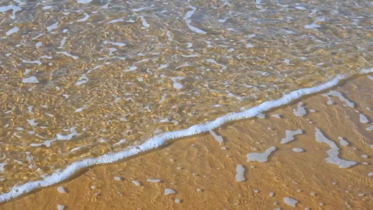 夏天的海边海滩上波浪泛起朵朵浪花视频素材