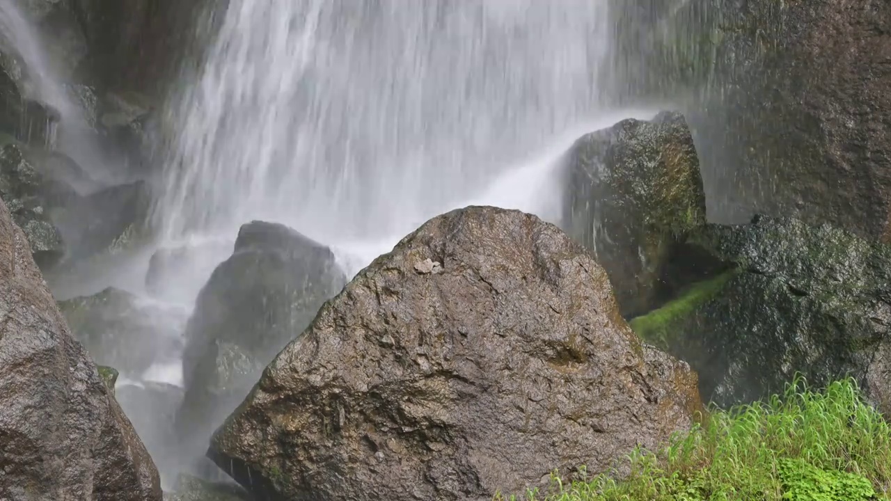 瀑布的水流拍打在岩石上溅起水汽视频下载