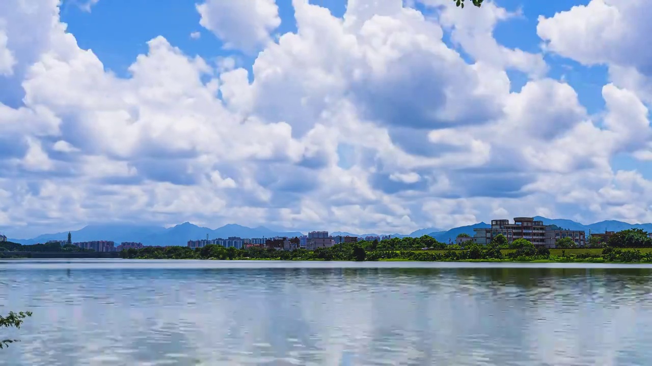 蓝天白云飘过平静湖面群山环绕风景优美视频素材