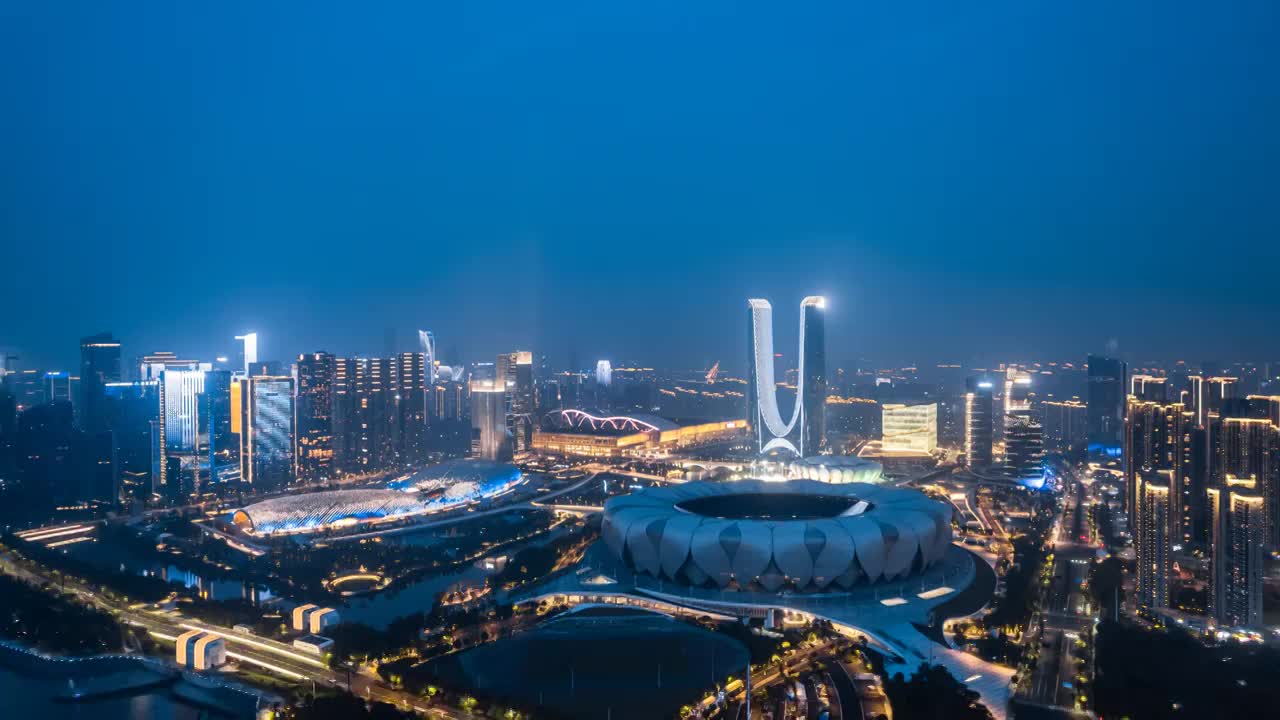 中国浙江杭州奥体中心体育场和杭州之门航拍夜景延时摄影视频素材