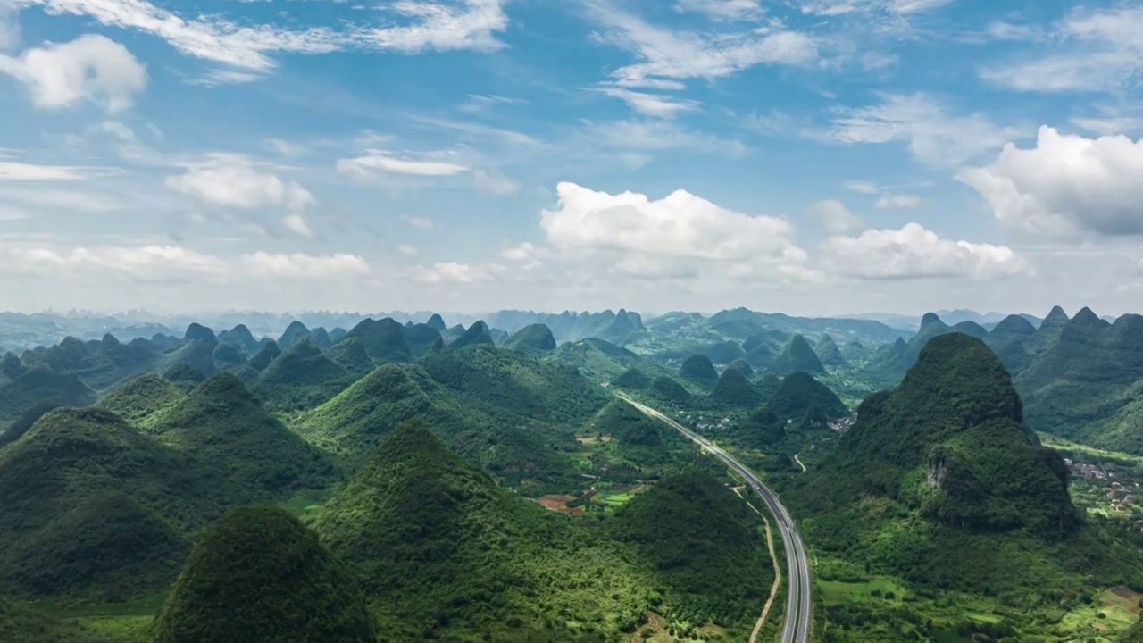 蓝天白云下桂林喀斯特地貌山谷中穿行的高速公路视频素材