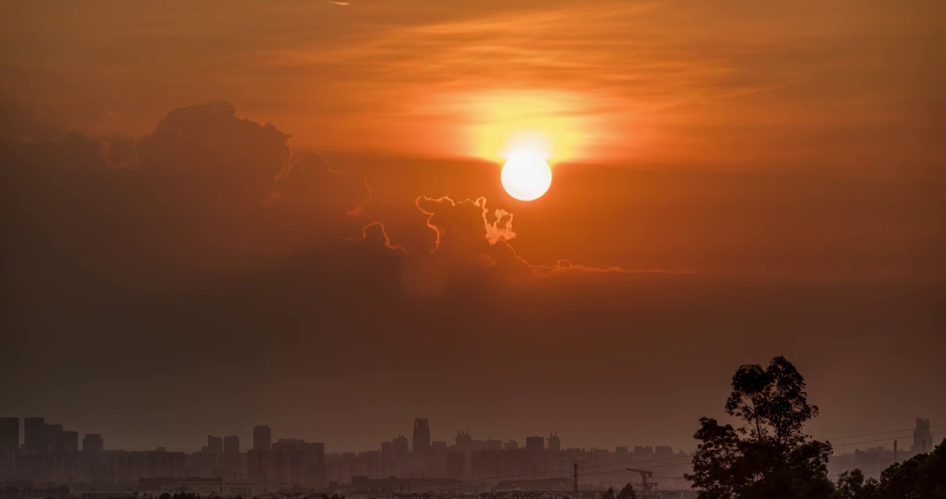 太阳在城市上空升起，直到整个画面变成橙黄色，长焦拍摄视频素材