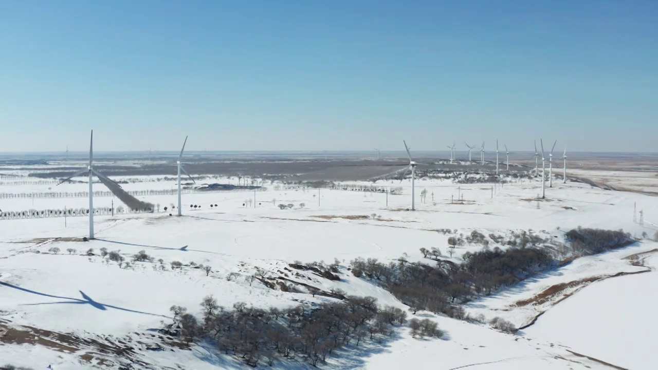 航拍大庆市杜尔伯特县冬季雪地中的风力发电视频素材