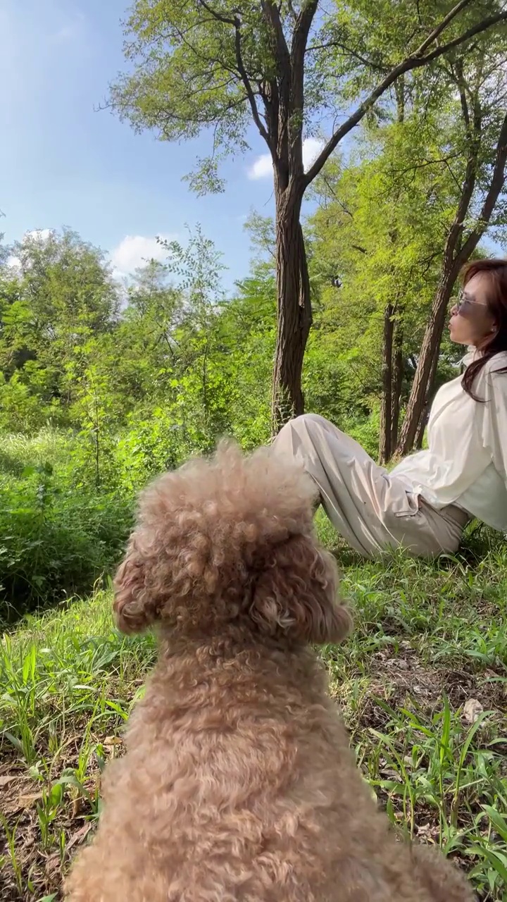 一个穿防晒服的女人和宠物犬在享受大自然的景色视频素材