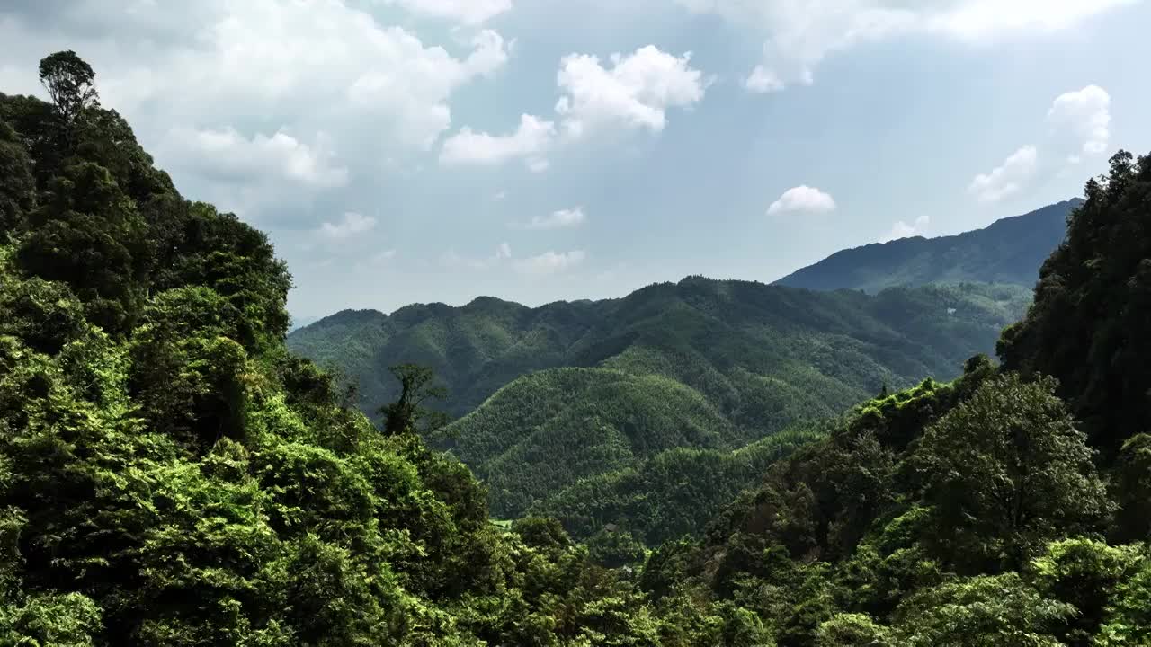 无人机从垭口飞出拍摄桂林山区山谷里的村庄和梯田视频素材