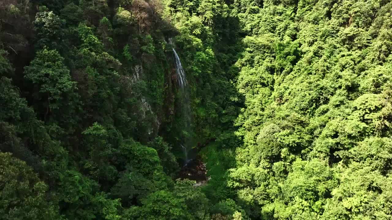 航拍晴朗天空下桂林山区峡谷中的森林瀑布视频素材