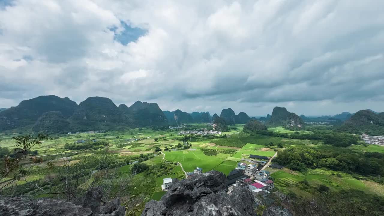 蓝天白云下在山顶俯瞰桂林喀斯特山峰间的村庄和稻田视频素材