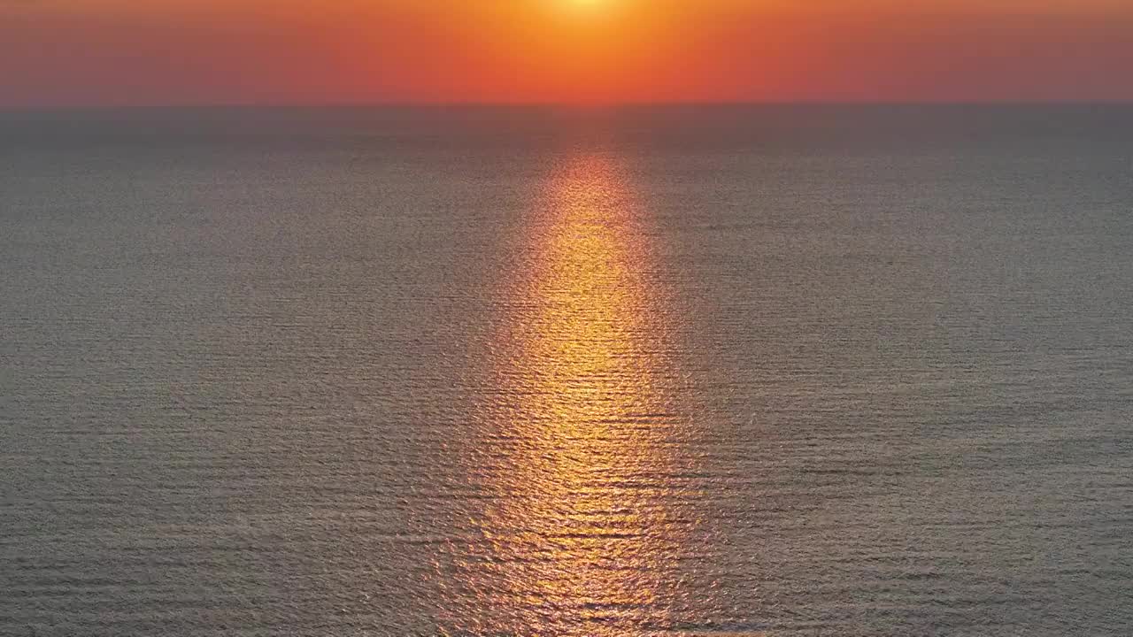 航拍青海湖水面上的日出风光（侧飞拍摄）视频素材