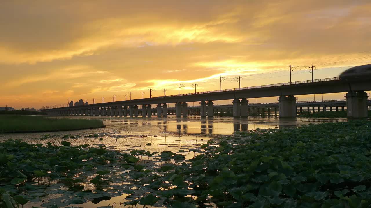 傍晚时分晚霞里的苏州阳澄湖上高铁与车流风景航拍视频素材