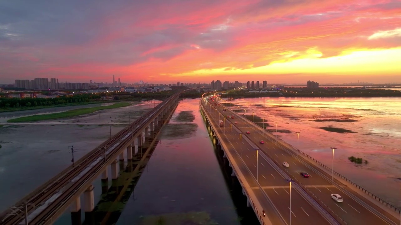 傍晚时分晚霞里的苏州阳澄湖上高铁与车流风景航拍视频素材