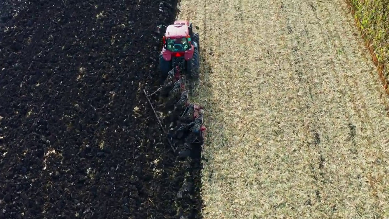 航拍三江平原正在翻地的农用机械黑土地视频素材