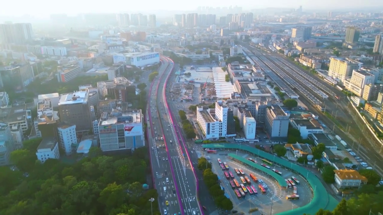 日落航拍都市火车站枢纽广场与公交车总站繁忙景象，车辆进出行人络绎不绝出租车公交车站场运作畅顺铁路枢纽视频素材