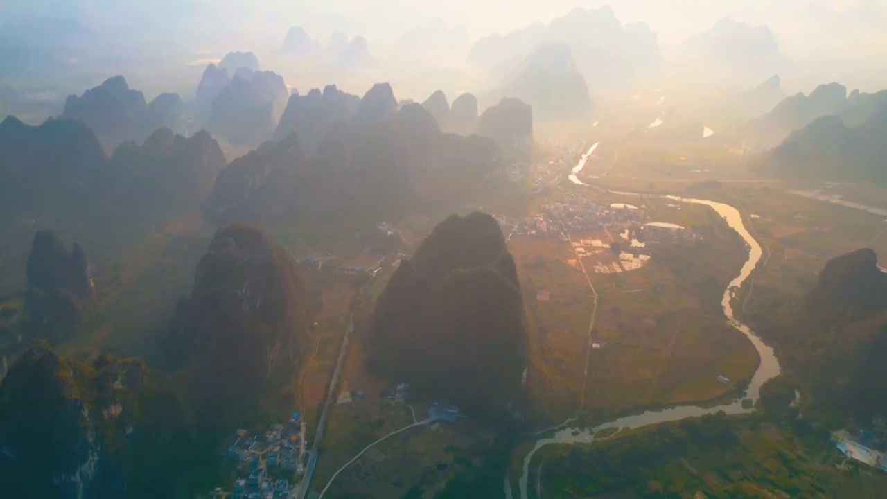 清晨的喀斯特地貌是一幅宁静而自然的田园风光，在晨雾的缭绕中大山之间的峰林起伏呈现出强烈的立体感水墨画视频素材