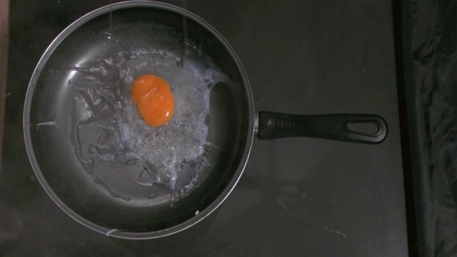 鸡蛋以超慢的动作掉进厨房的平底锅里视频素材