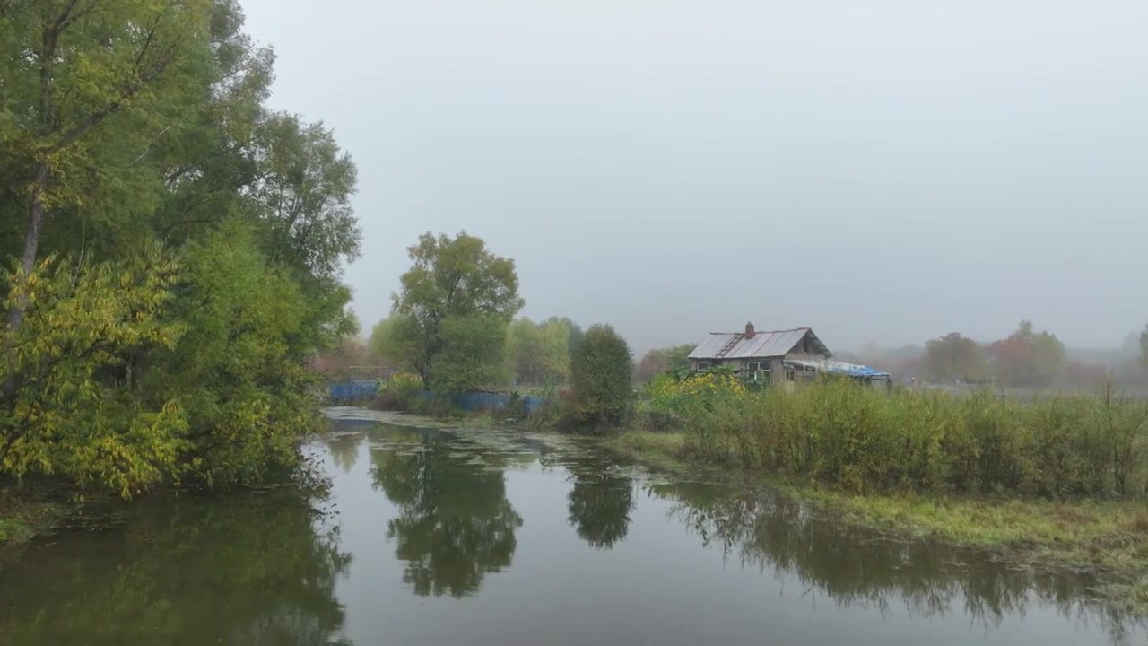 晨雾中的河岸农舍视频素材