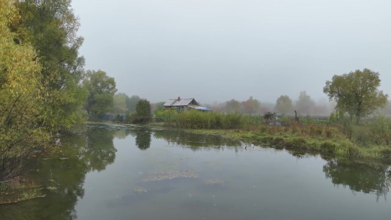 晨雾中河岸山里人家视频素材