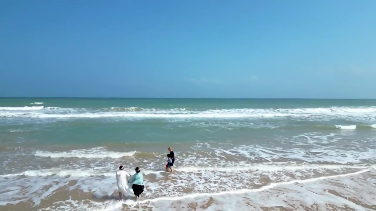 航拍海南琼海人像：一家人在博鳌海岸线沙滩嬉戏冲浪视频素材