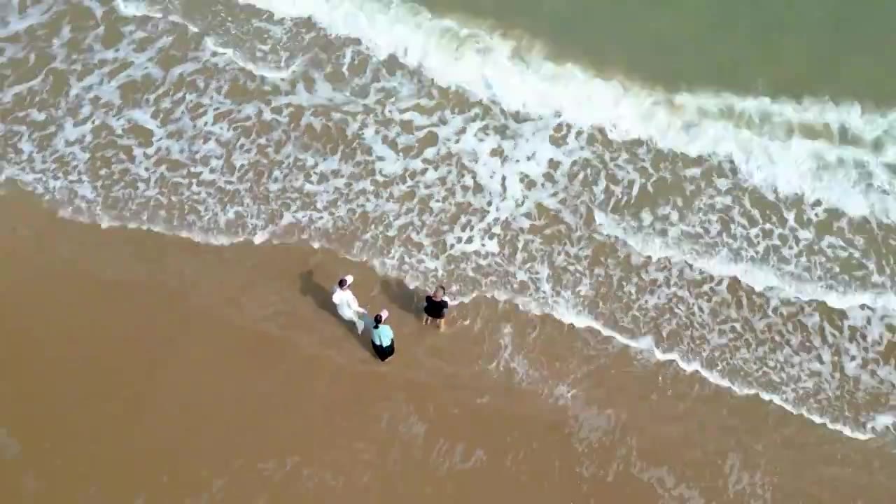 航拍海南琼海人像：一家人在博鳌海岸线沙滩嬉戏冲浪视频素材