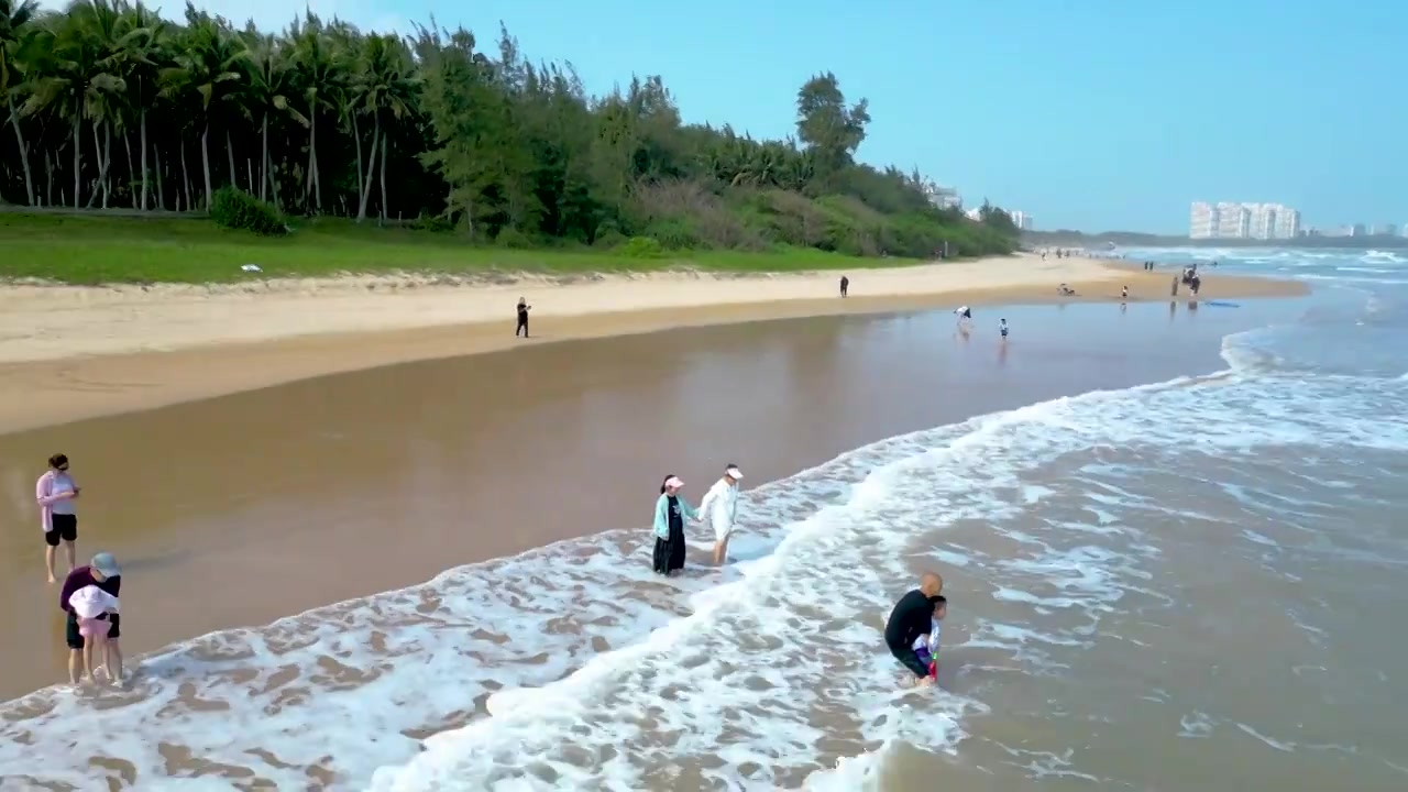 航拍海南琼海人像：一家人在博鳌海岸线沙滩嬉戏冲浪视频素材