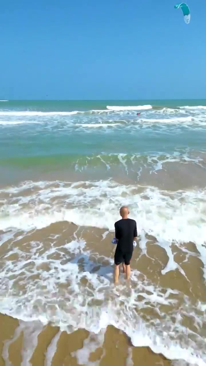 航拍海南琼海人像：爷爷和孙子在博鳌海岸线沙滩嬉戏冲浪视频素材