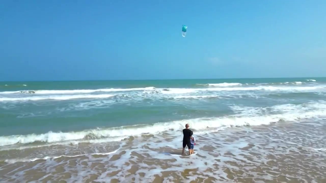 航拍海南琼海人像：爷爷和孙子在博鳌海岸线沙滩嬉戏冲浪视频素材