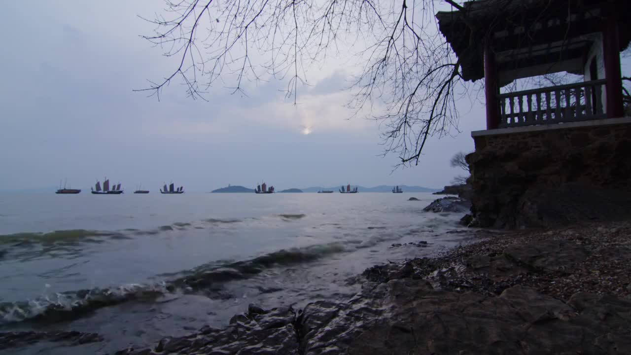 鼋头渚岸边看日落下的帆船和太湖仙岛视频素材