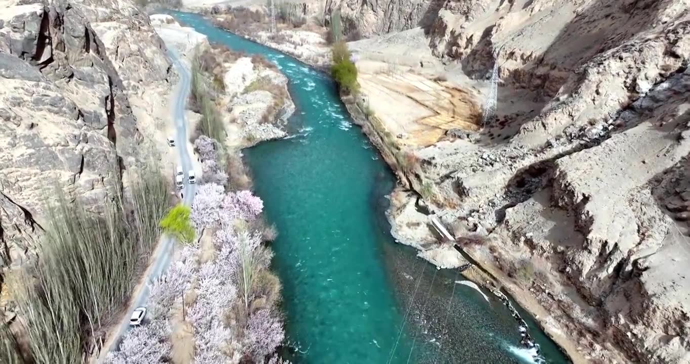 碧绿的河流穿过新疆杏花村 公路边鲜花盛开 南疆旅行视频素材