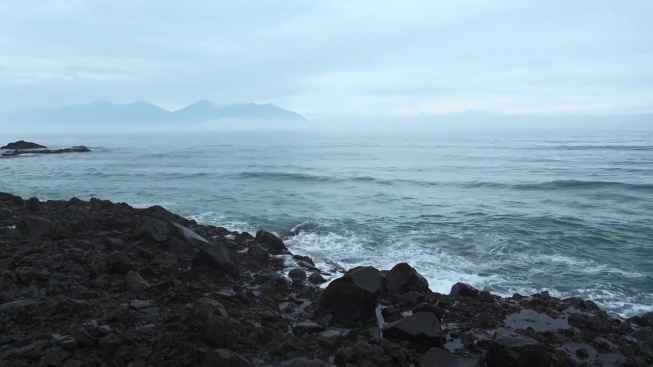 海岩石与移动的波浪在背景多云的地平线。夹。岩石的岩石视频素材