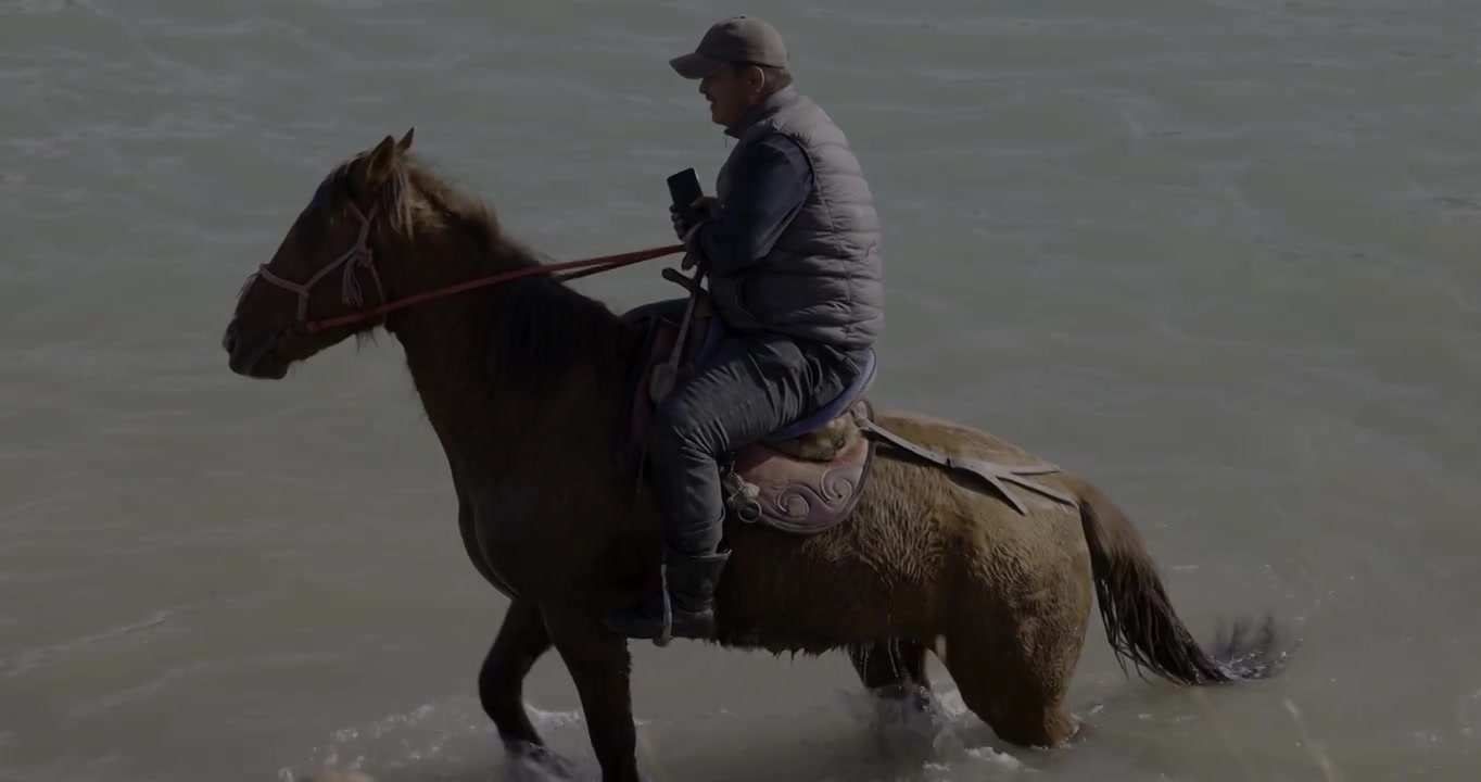 哈萨克族牧民在河边牧马视频素材