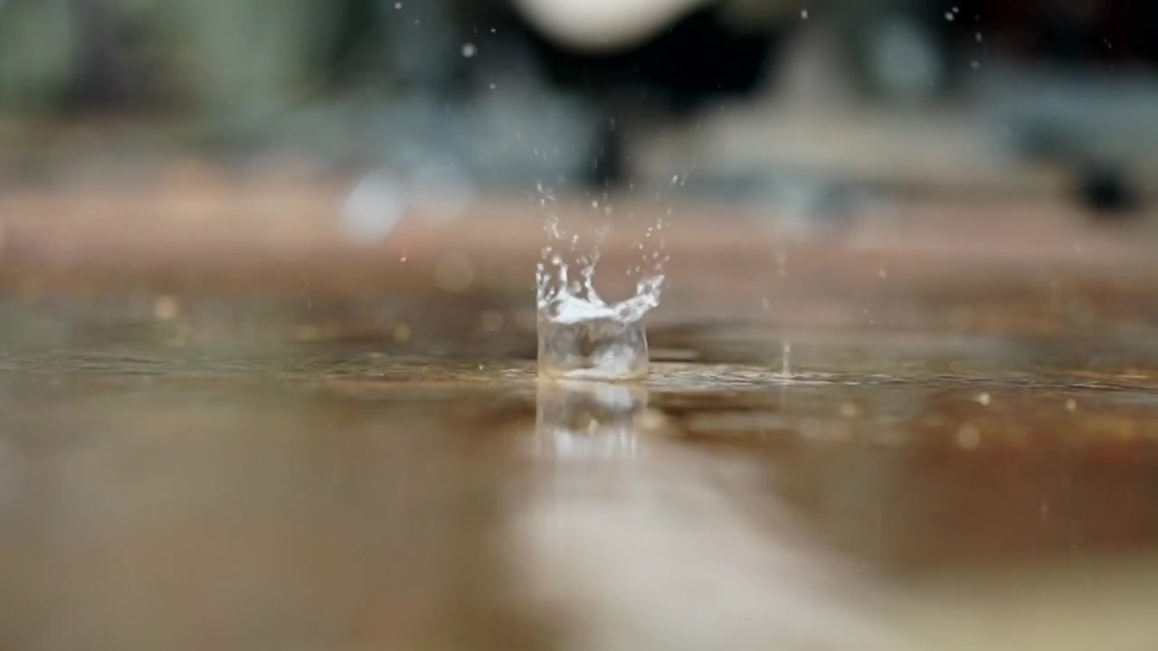 下雨天，地面上积水，雨滴落下溅起水花空境视频素材