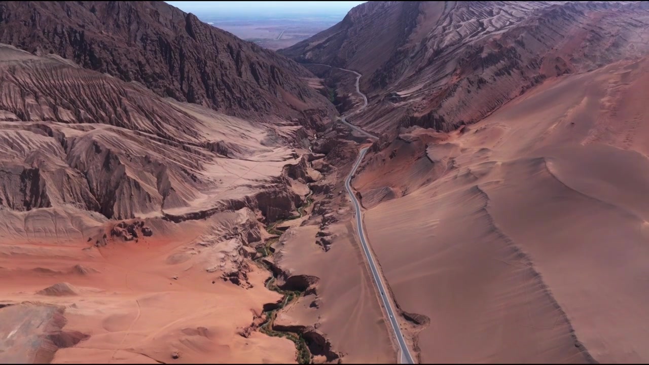 新疆吐鲁番火焰山 沙漠里通往峡谷的公路俯拍航拍视频素材