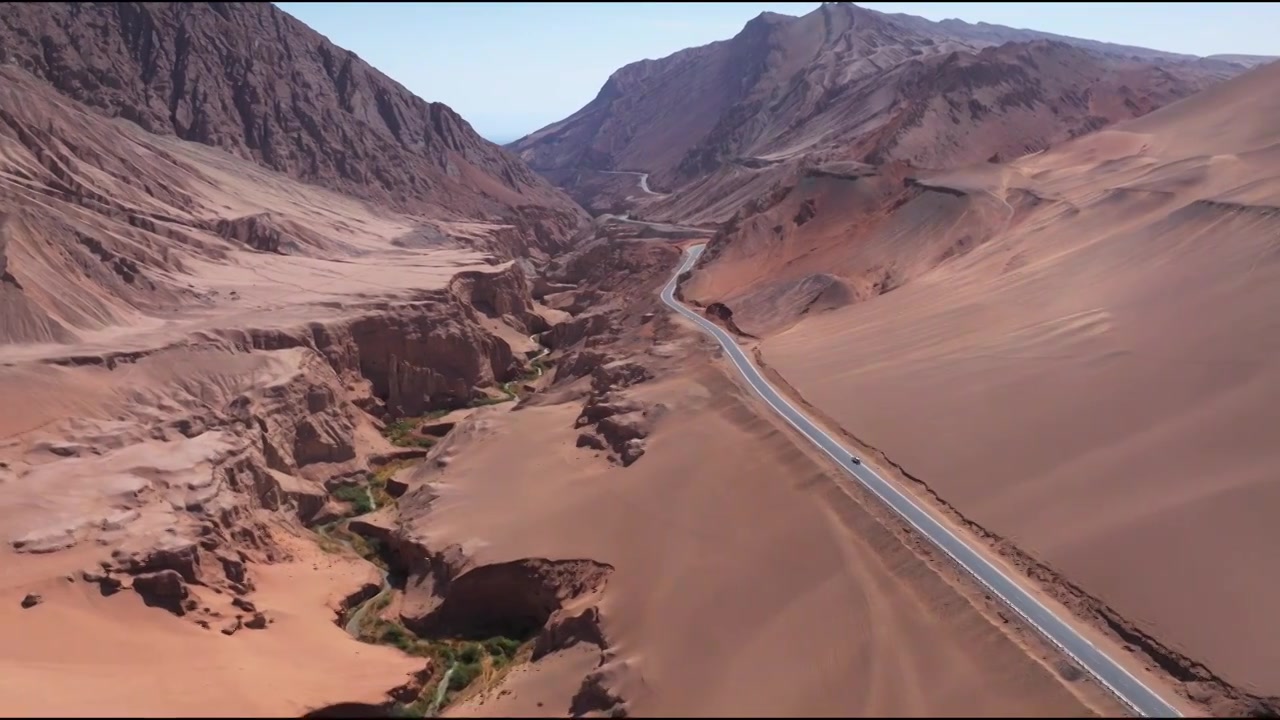 新疆吐鲁番火焰山 沙漠里通往峡谷的公路航拍视频素材