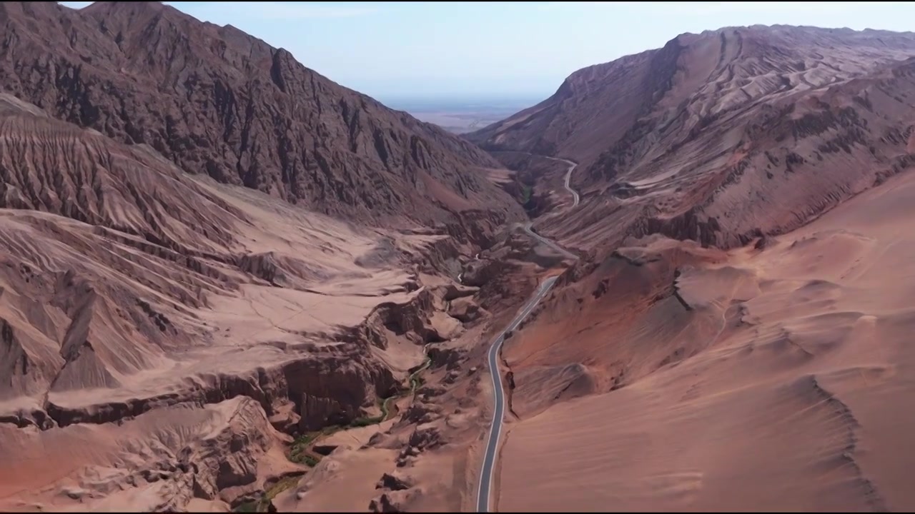 新疆吐鲁番火焰山 沙漠里通往峡谷的公路航拍视频素材