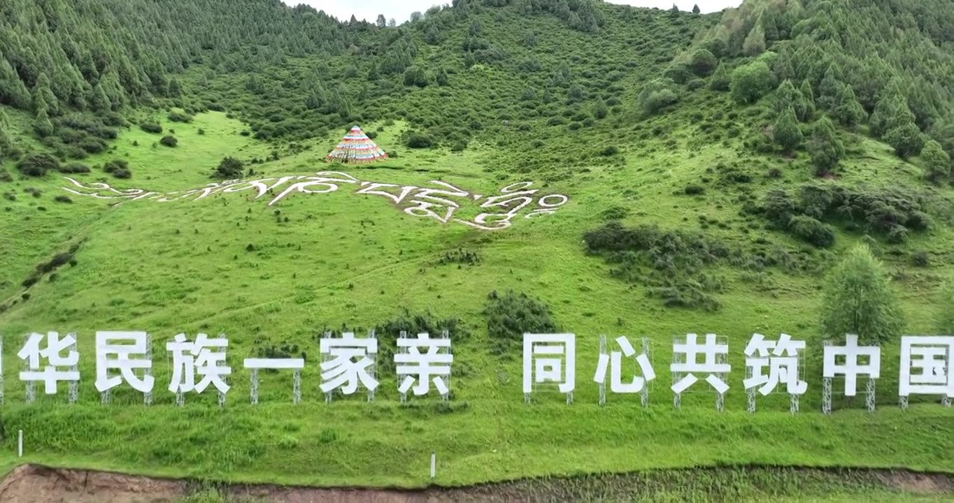 航拍高山牧场上的“中华民族一家亲，同心共筑中国梦”文字视频素材