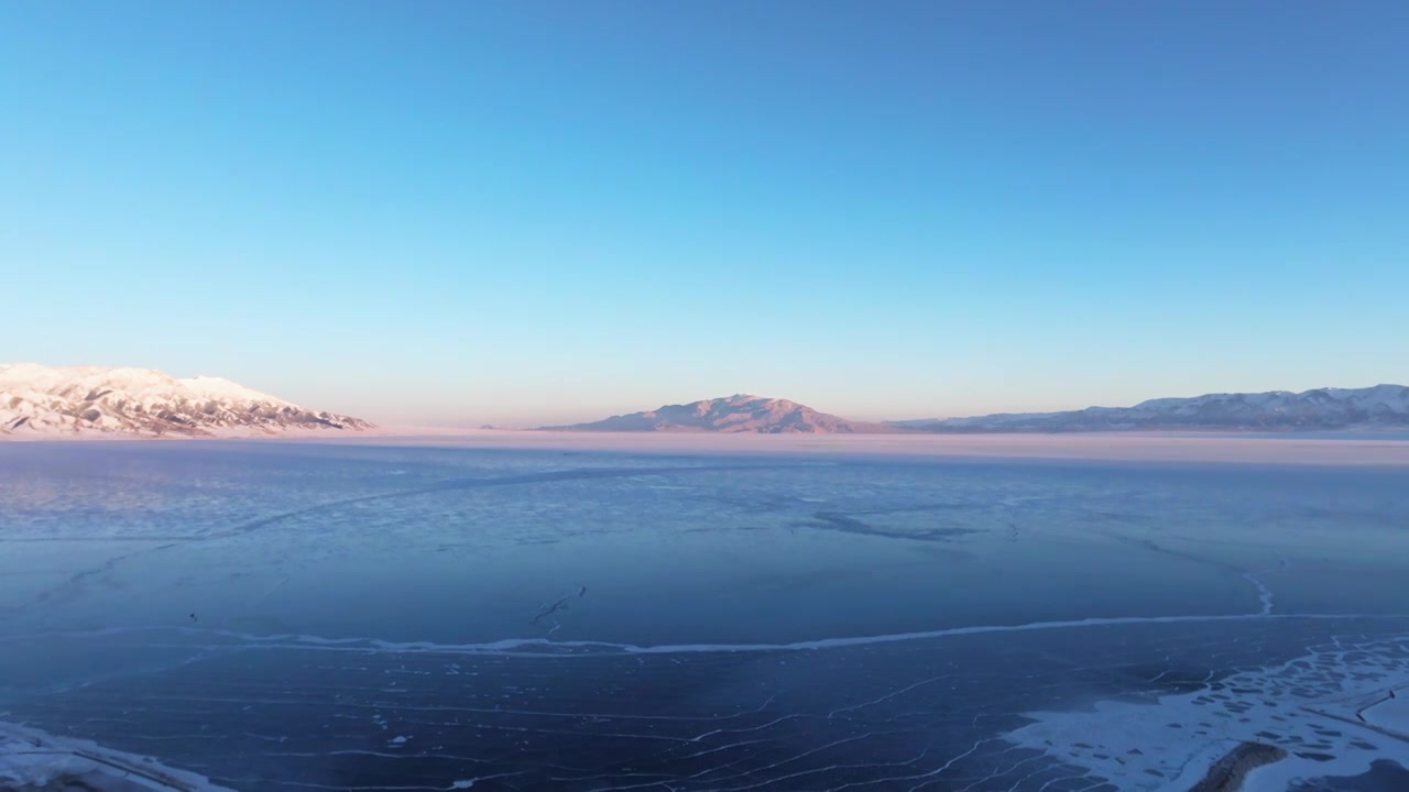 航拍冬季新疆赛里木湖雪山冰湖蓝冰日照金山夕阳雪山纹理视频下载