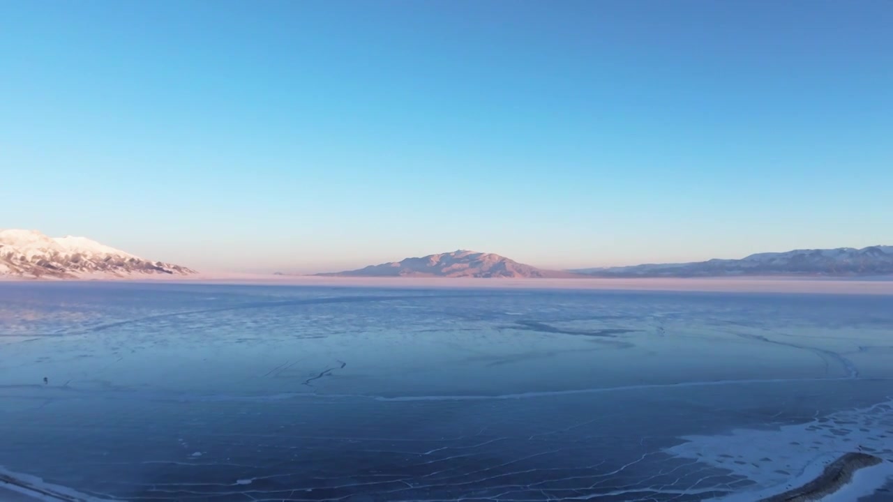 航拍冬季新疆赛里木湖雪山冰湖蓝冰日照金山夕阳雪山纹理视频下载