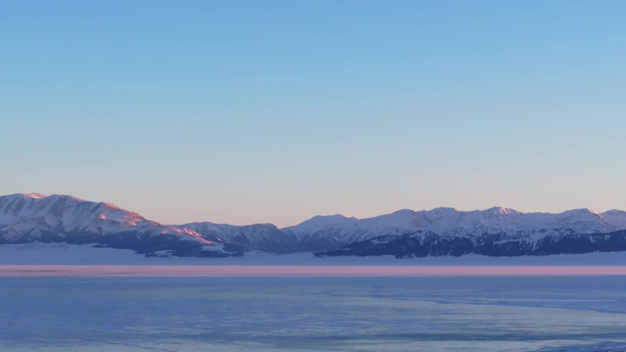 航拍冬季新疆赛里木湖雪山冰湖蓝冰日照金山夕阳雪山纹理视频下载