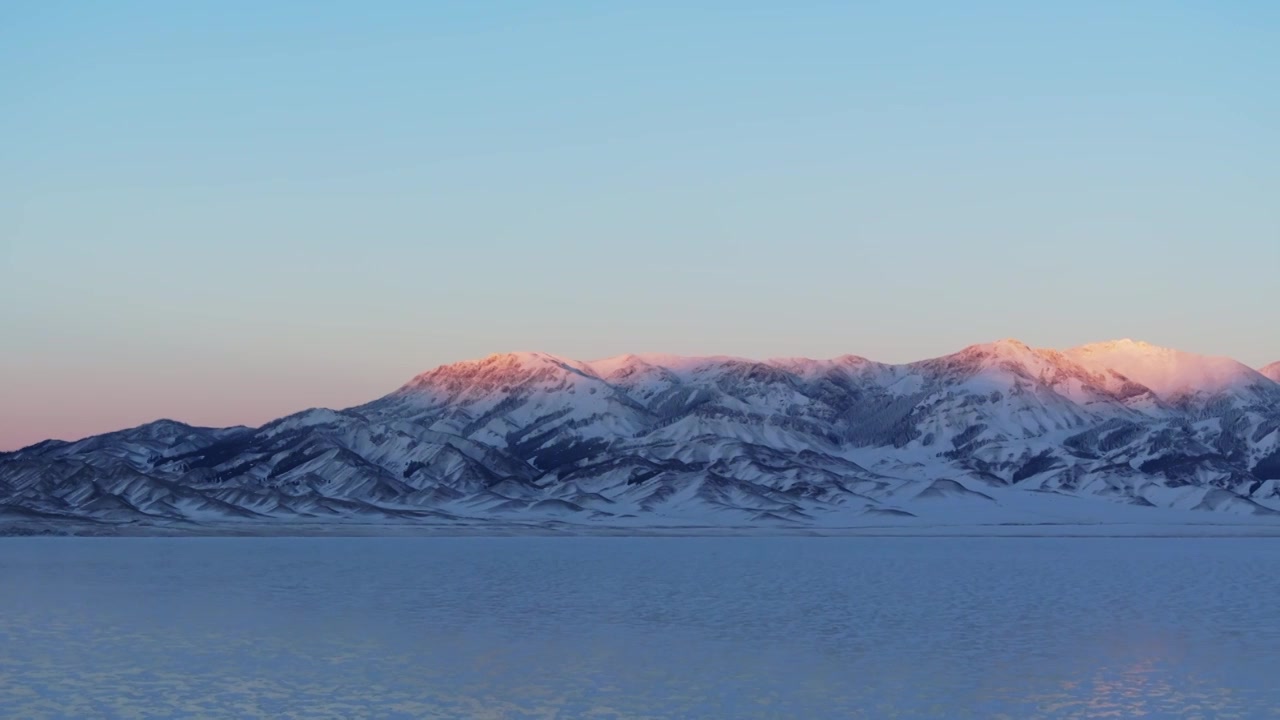 航拍冬季新疆赛里木湖雪山冰湖蓝冰日照金山夕阳雪山纹理视频素材