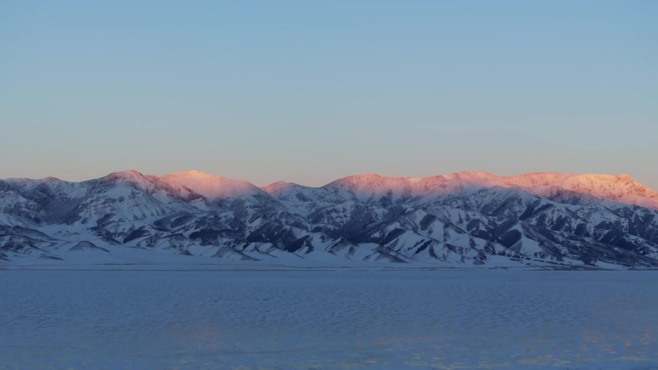 航拍冬季新疆赛里木湖雪山冰湖蓝冰日照金山夕阳雪山纹理视频下载