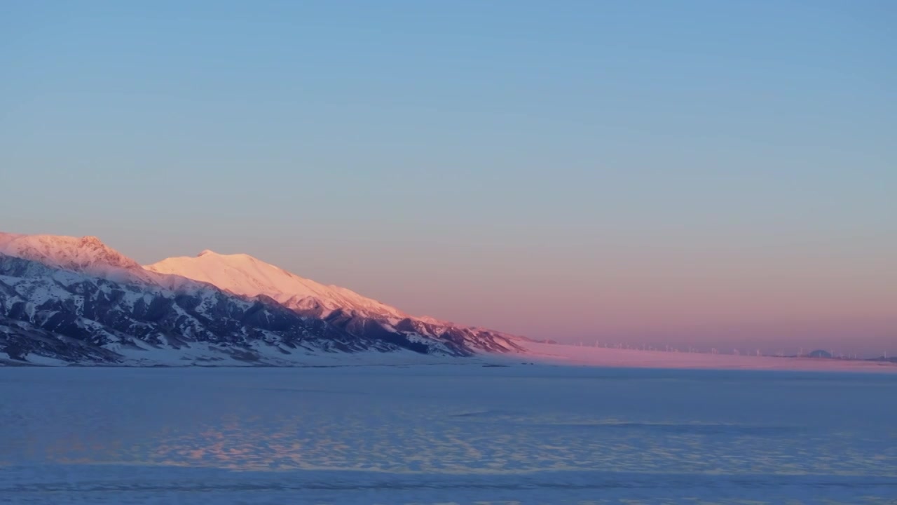 航拍冬季新疆赛里木湖雪山冰湖蓝冰日照金山夕阳雪山纹理视频素材