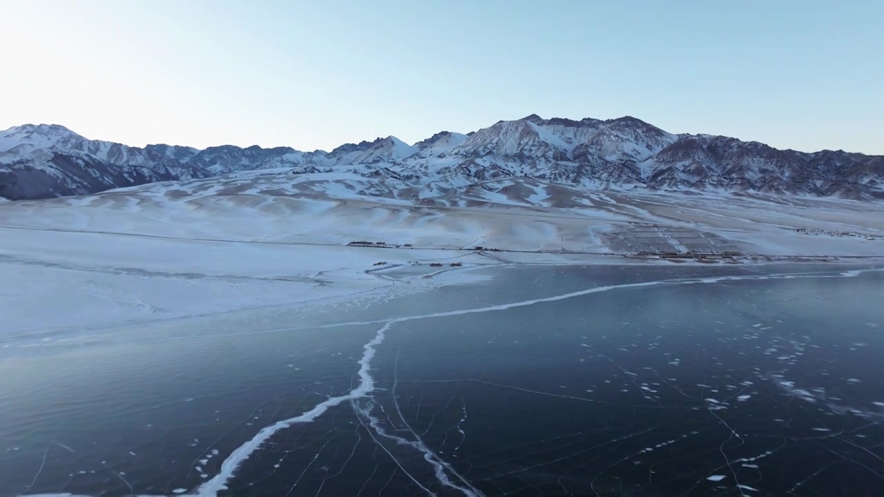 航拍冬季新疆赛里木湖雪山冰湖蓝冰日照金山夕阳雪山纹理视频下载