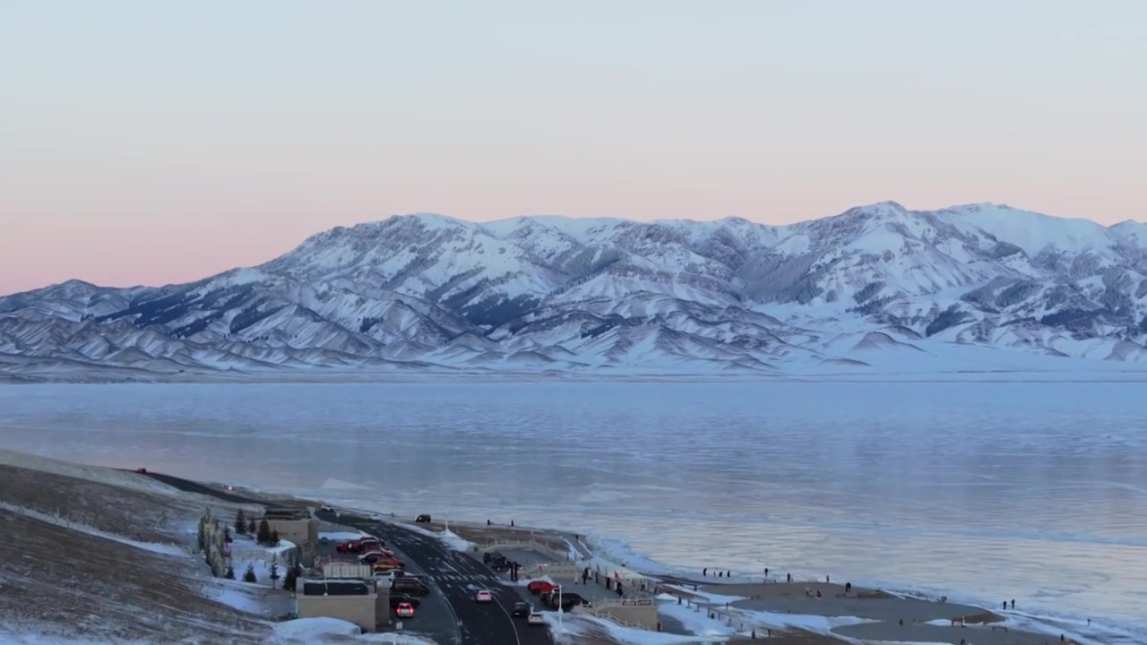 航拍冬季新疆赛里木湖雪山冰湖蓝冰日照金山夕阳雪山纹理视频下载